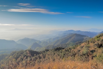 Mountain view morning of top hills around with soft fog and blue sky background, sunrise at top view point highest of Doi Ang Khang, Chiang Mai, northern of Thailand.