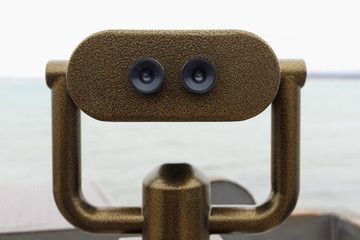 Public binocular telescope on the observation deck overlooking the sea.