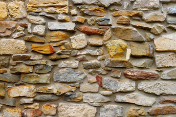 Texture collapsing stone wall of old house with brick masonry.