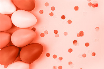 Coral Easter eggs on pink background. Flatlay.