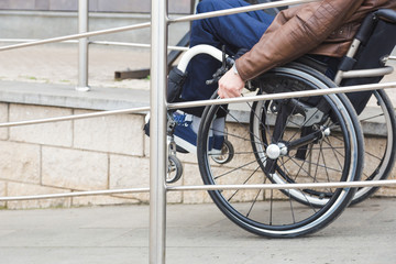 Man in a wheelchair use a wheelchair ramp.