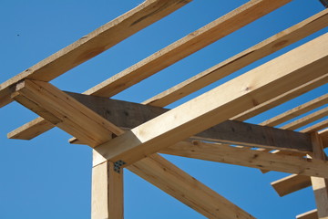 the wooden frame of the roof against the sky