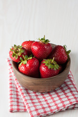 Fresh natural strawberries in wooden bowl. Healthy vegan food concept. Summer eco fruits and vegetables.