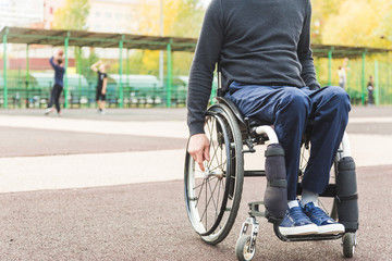 Obraz premium Young man in a wheelchair sitting on the sports field.