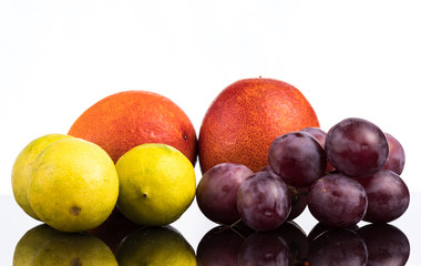 Bloody orange, lime and grapes close up close up with reflection on white and black background