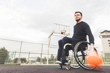 Young man in a wheelchair playing basketball.