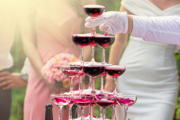 pyramid from glasses of red champagne on wedding party
