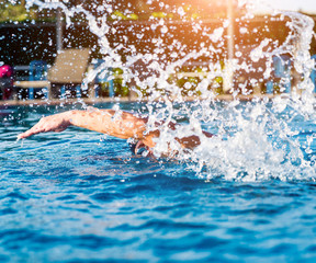 Young athletic man swimming in the swimming pool