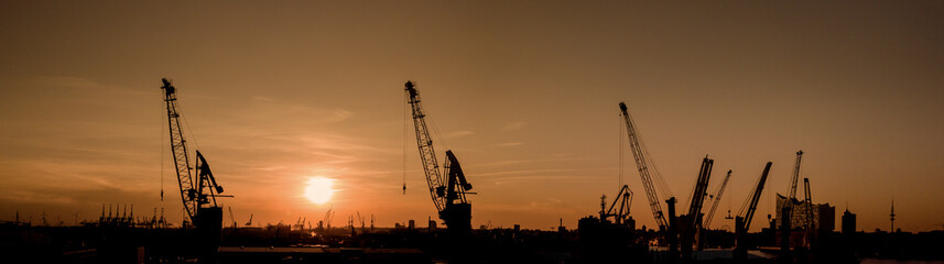 Obraz premium Silhouette vom Hamburger Hafen bei Sonnenuntergang