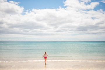 Fototapeta na wymiar teen girl playing on a beach by sea on holiday