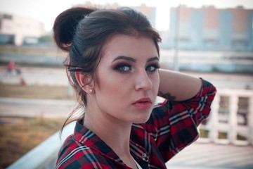 Girl in an abandoned building sits on concrete in jeans 