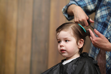 A little boy is trimmed in the hairdresser's bright emotions on face