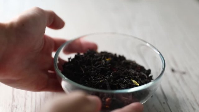 Dry flavoured black tea on a wooden background. Close-up, copy space.