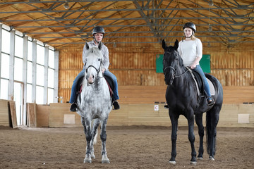 People on a horse training in a wooden arena