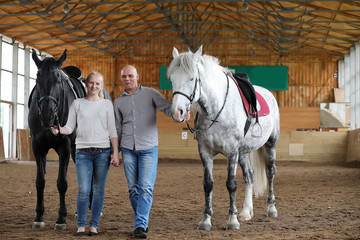People on a horse training in a wooden arena