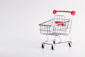 Grocery cart close up. The cart under products standing on a white background. Empty grocery cart on white background  with copy space.