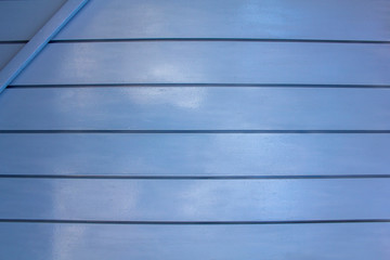 gray blue wall metal panel fence. horizontal lines. rough surface texture