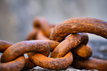 rusty big chain lying on a stone