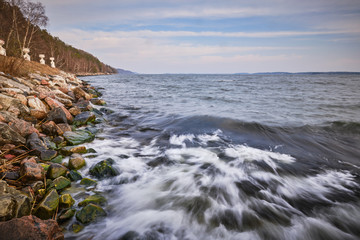 Obraz premium waves breaking over moss-covered rocks