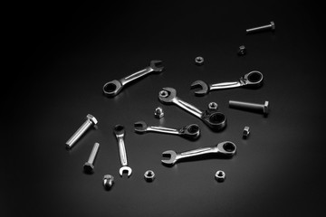 Nuts, bolts, tool wrench, ratchet on a dark background.