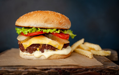  Delicious homemade hamburger with beef, lettuce, cheese, cucumber and french fries  on stone background