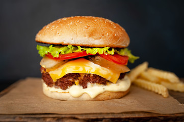  Delicious homemade hamburger with beef, lettuce, cheese, cucumber and french fries  on stone background