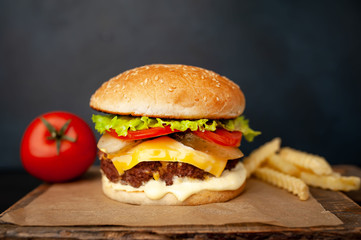  Delicious homemade hamburger with beef, lettuce, cheese, cucumber and french fries  on stone background
