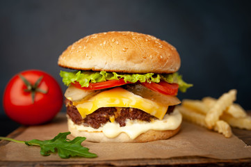  Delicious homemade hamburger with beef, lettuce, cheese, cucumber and french fries  on stone background