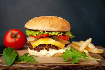  Delicious homemade hamburger with beef, lettuce, cheese, cucumber and french fries  on stone background