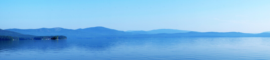 Beautiful blue sky on the lake. Sunset or dawn. White clouds on a blue sky. Natural phenomenon. Suitable for postcards, Wallpapers.