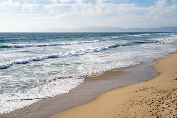 Sandy beach in Manhattan Beach California. Waves roll in