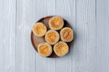 close up of egg tarts on wooden plate