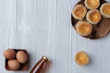 close up of egg tarts on wooden plate