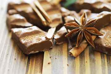 A bar of milk chocolate on the table. Chocolate with nuts and cinnamon.