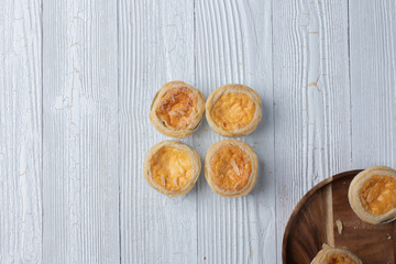 close up of egg tarts on wooden plate