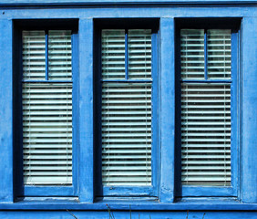 Blue framed window with three vertica panes of glass