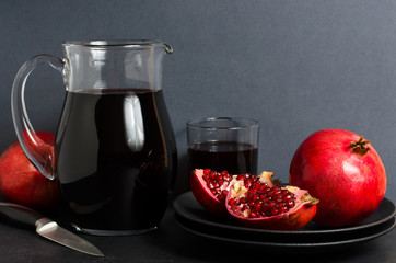 Pomegranate, pomegranate juice in a glass Cup. Dark background. Side view. Copy space