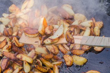 Fresh potato boiled in large restaurant frying pan. Picnic healthy food cooking at large metallic pan.