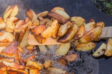 Fresh potato boiled in large restaurant frying pan. Picnic healthy food cooking at large metallic pan.