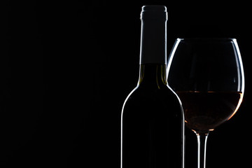  wine bottle and wine glass in a black background