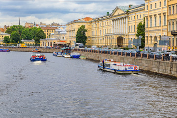 Obraz premium Waterfront buildings on the banks of river Neva and tourist boats on the water in Saint Petersburg