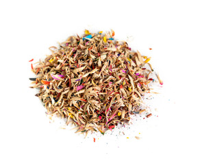 Heap of wooden shavings from colored pencils after sharpening with a knife on white background closeup