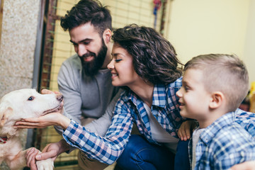 Happy family at dog shelter adopting a dog.