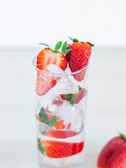 Strawberry in font of cocktail with ice isolated on white background with strawberry on top