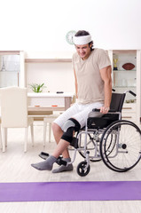 Injured young man doing exercises at home 