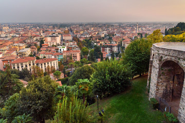 Fototapeta premium View of Bergamo and old bridge on Via Sant Alessandro street to upper city Cita Alta at sunset. Bergamo. Italy