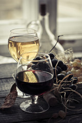 glasses of red and white wine and grapes