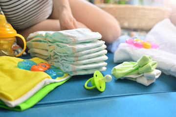 Pregnant woman packing bag for maternity hospital at home. Expectant mother folds clothes for a...