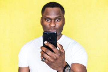 African American man taking pictures on a smartphone.