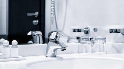 Luxury modern style faucet mixer on a white sink in a beautiful gray and white bathroom